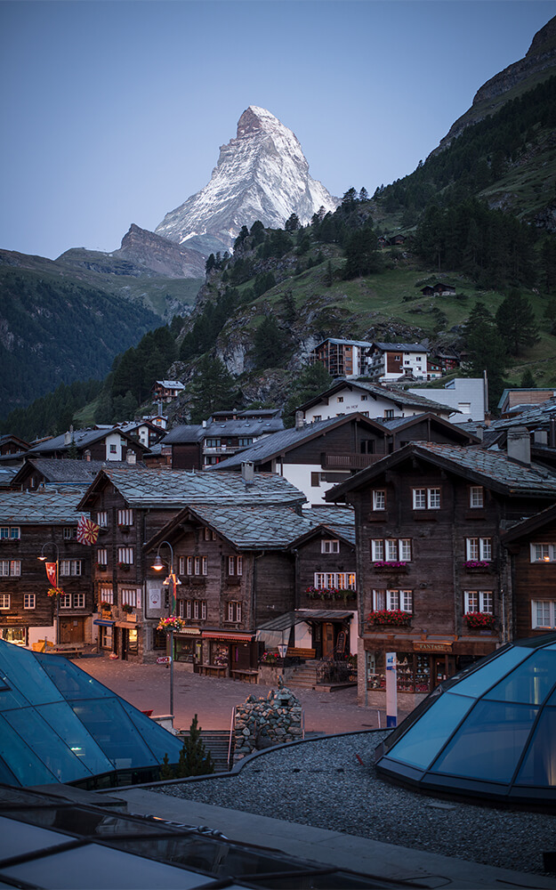 Traditional wooden chalets in Zermatt with sunset view of the Matterhorn peak