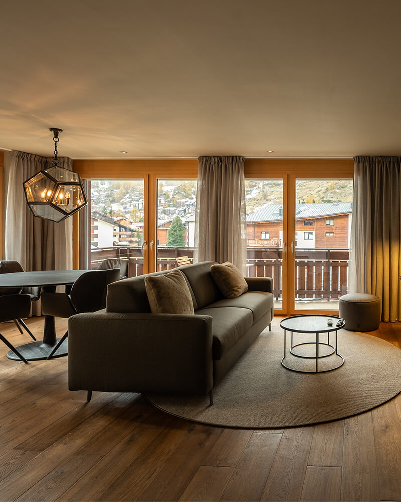 Elegant Zermatt apartment living room with balcony and panoramic village views