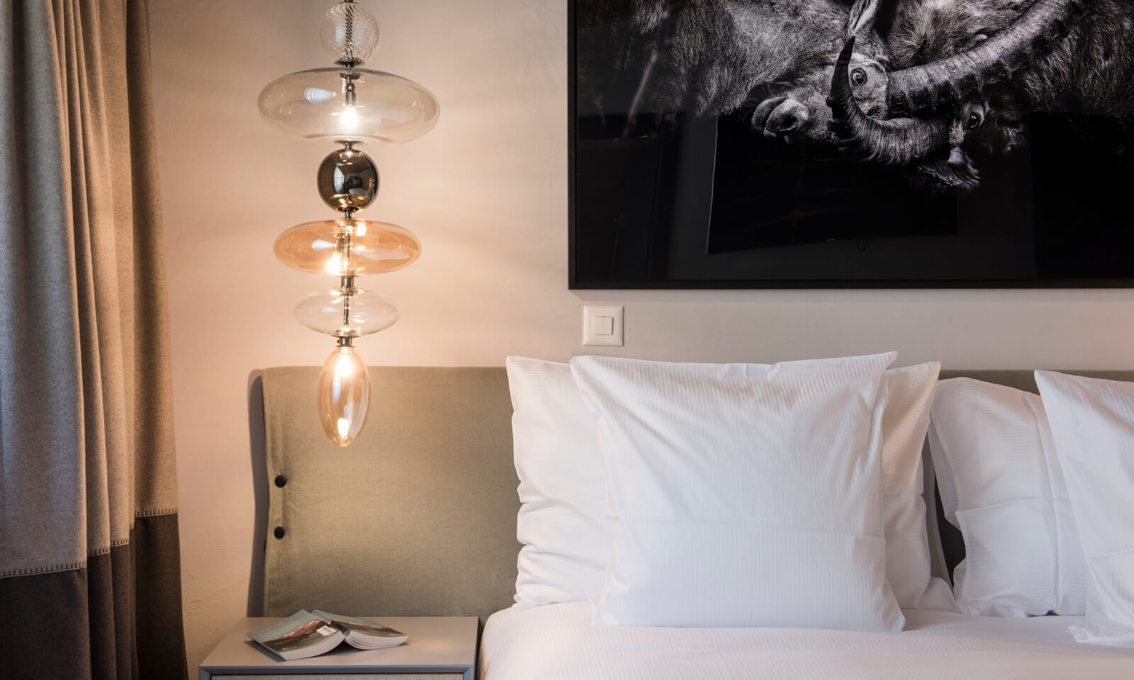 Modern bedside lamp and cozy pillows in Mount Whitney Apartment Zermatt
