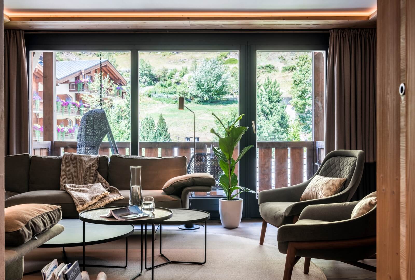 Modern living room with balcony and mountain scenery in Mount Whitney Apartment Zermatt