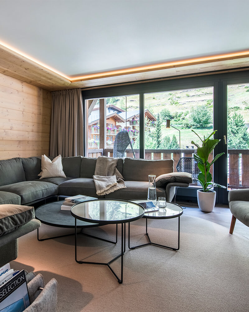 Stylish Zermatt apartment living room with sectional sofa and balcony mountain views