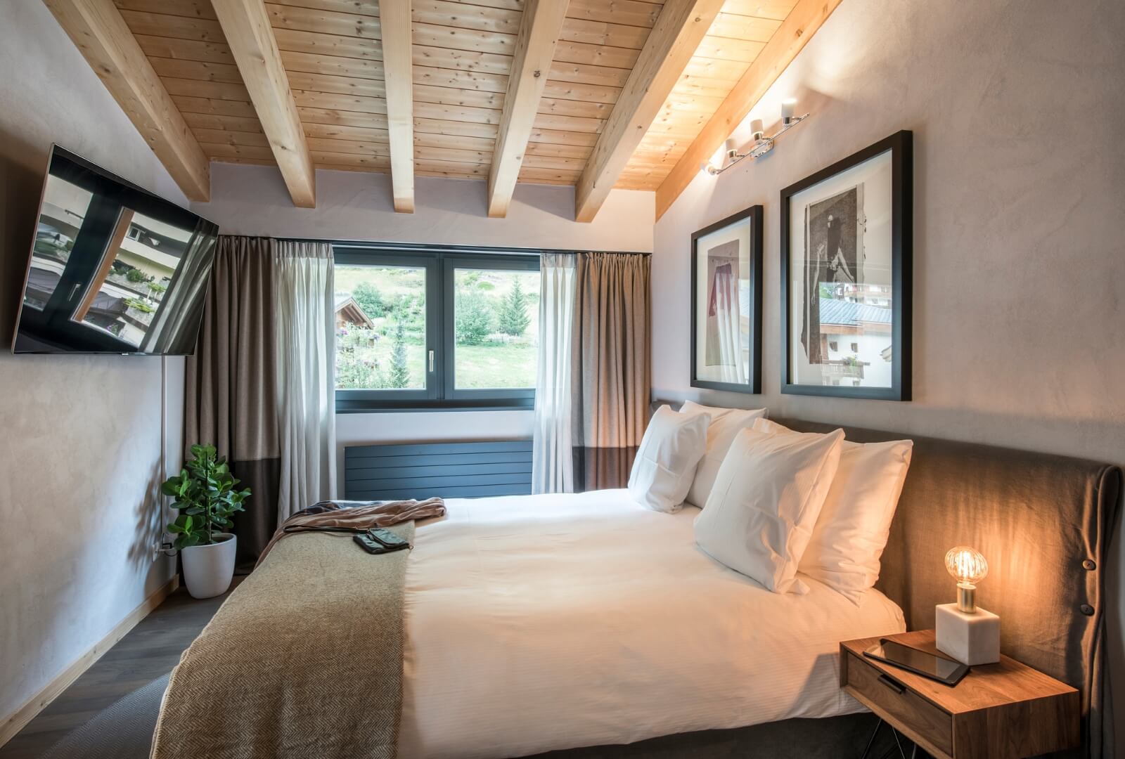 Stylish Zermatt holiday apartment bedroom with king-size bed and mountain-view window