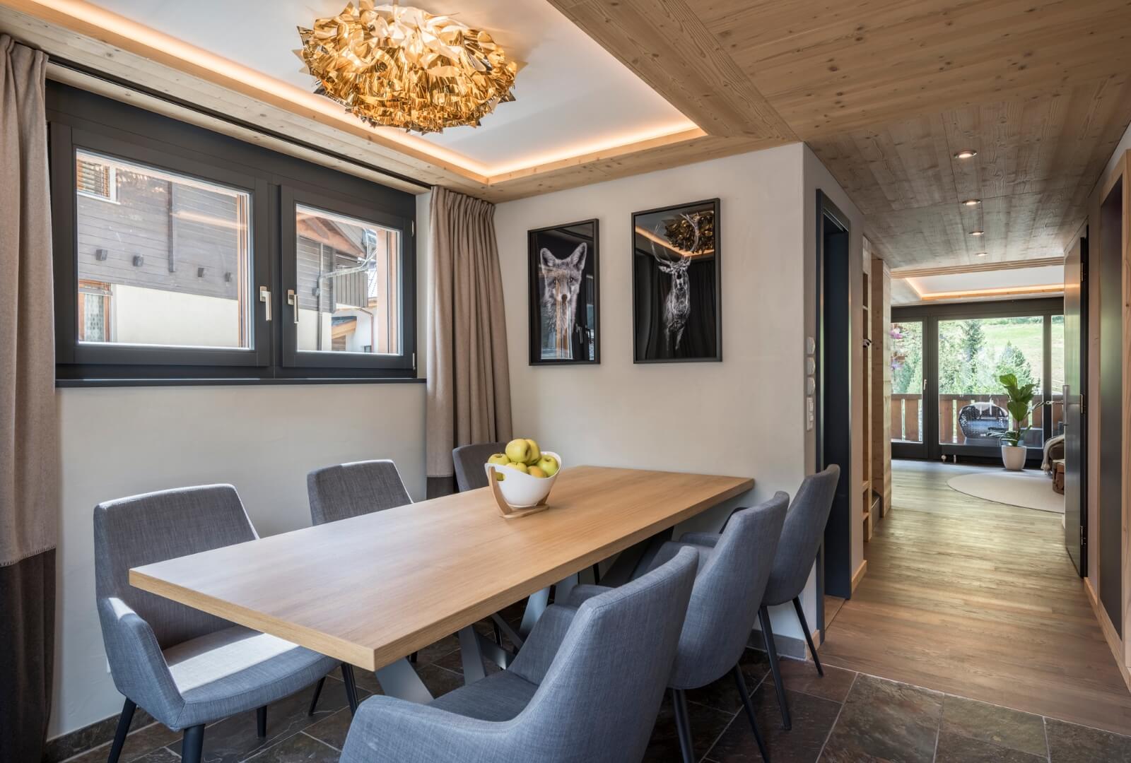 Elegant dining space in Zermatt duplex with wooden ceiling and modern alpine design