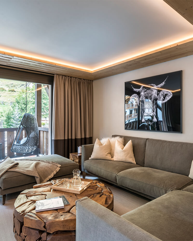 Contemporary Zermatt apartment living area with rustic wood table and balcony view