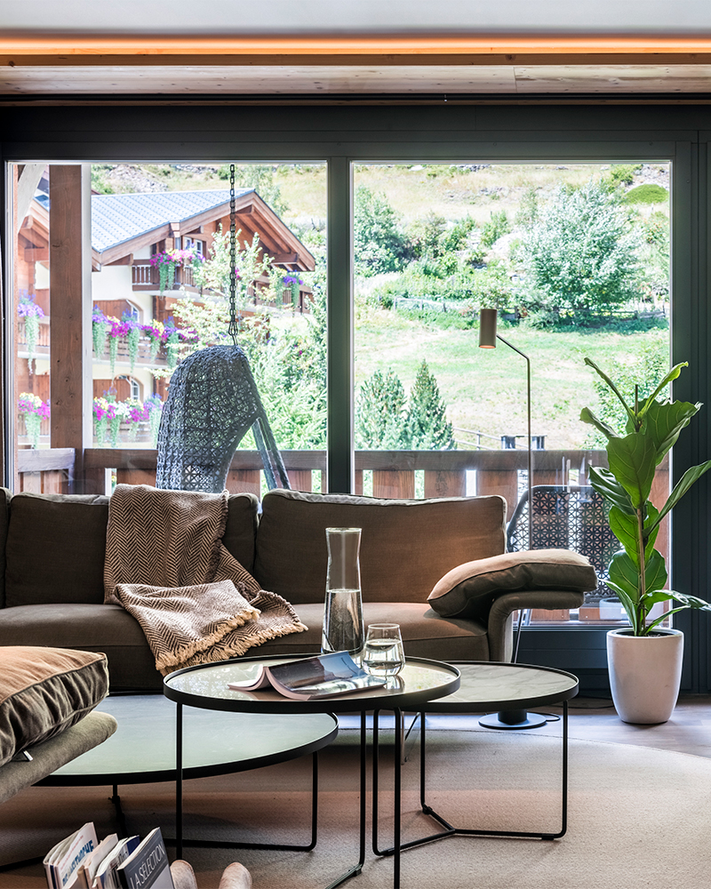 Bright Zermatt apartment living room with balcony, mountain views and cozy seating