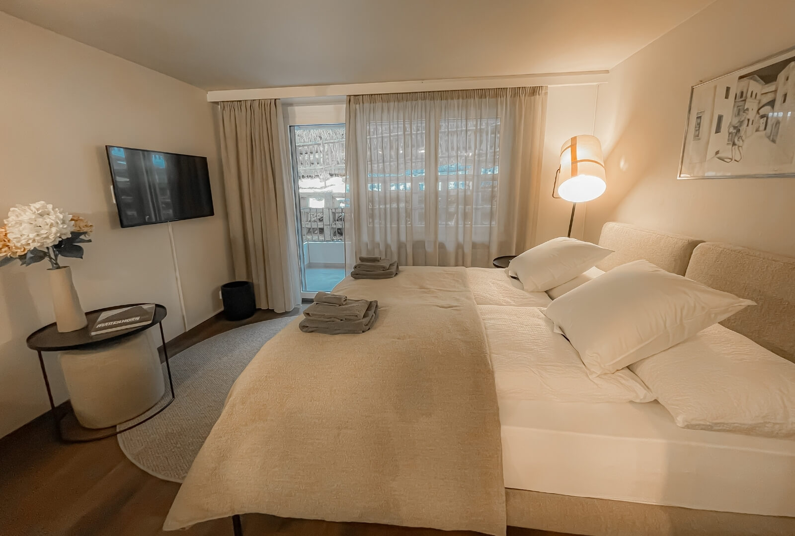 Bright Studio JaMi Zermatt bedroom with double bed, soft lighting and balcony view.