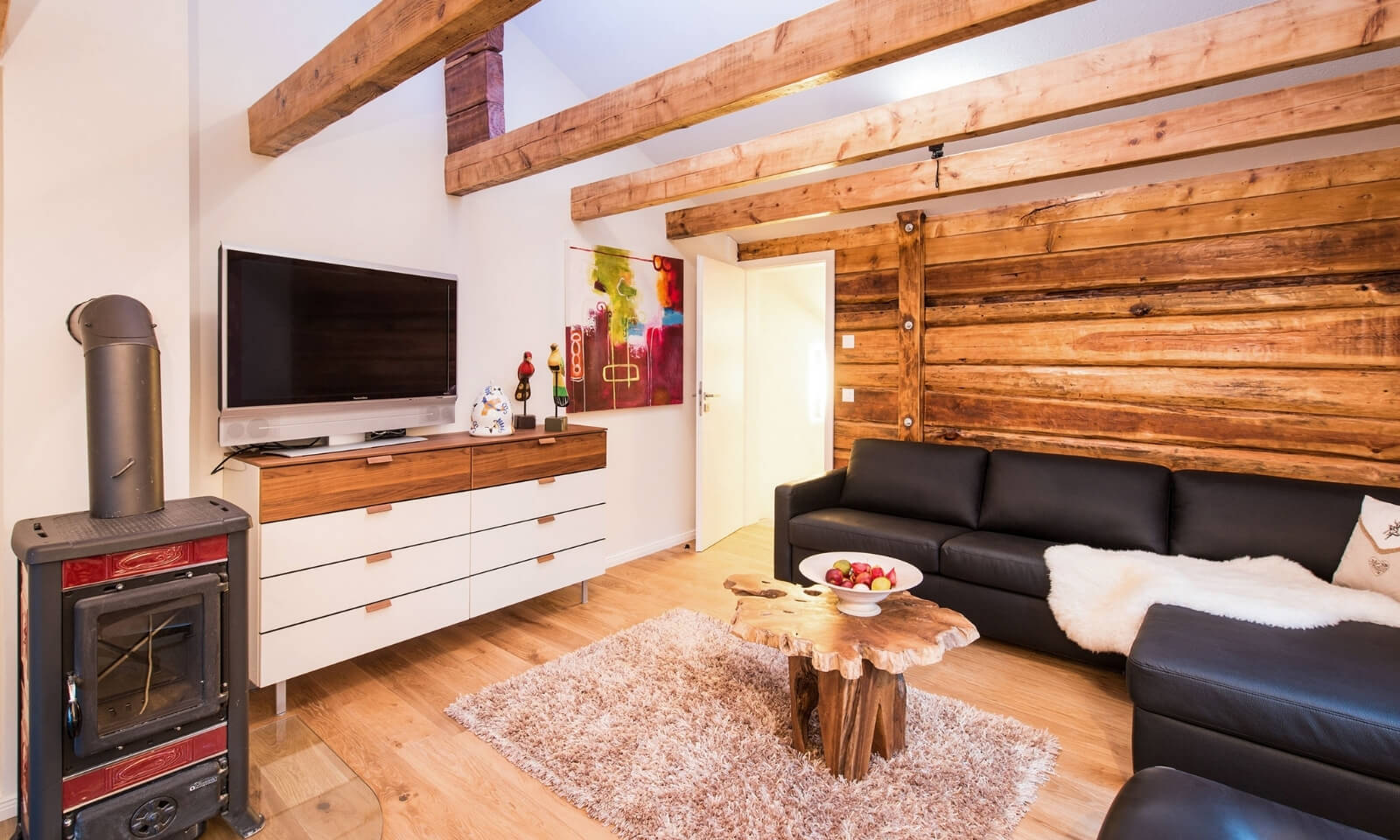 Stylish Chalet Zermatt living room with rustic wood wall, modern sofa, and fireplace