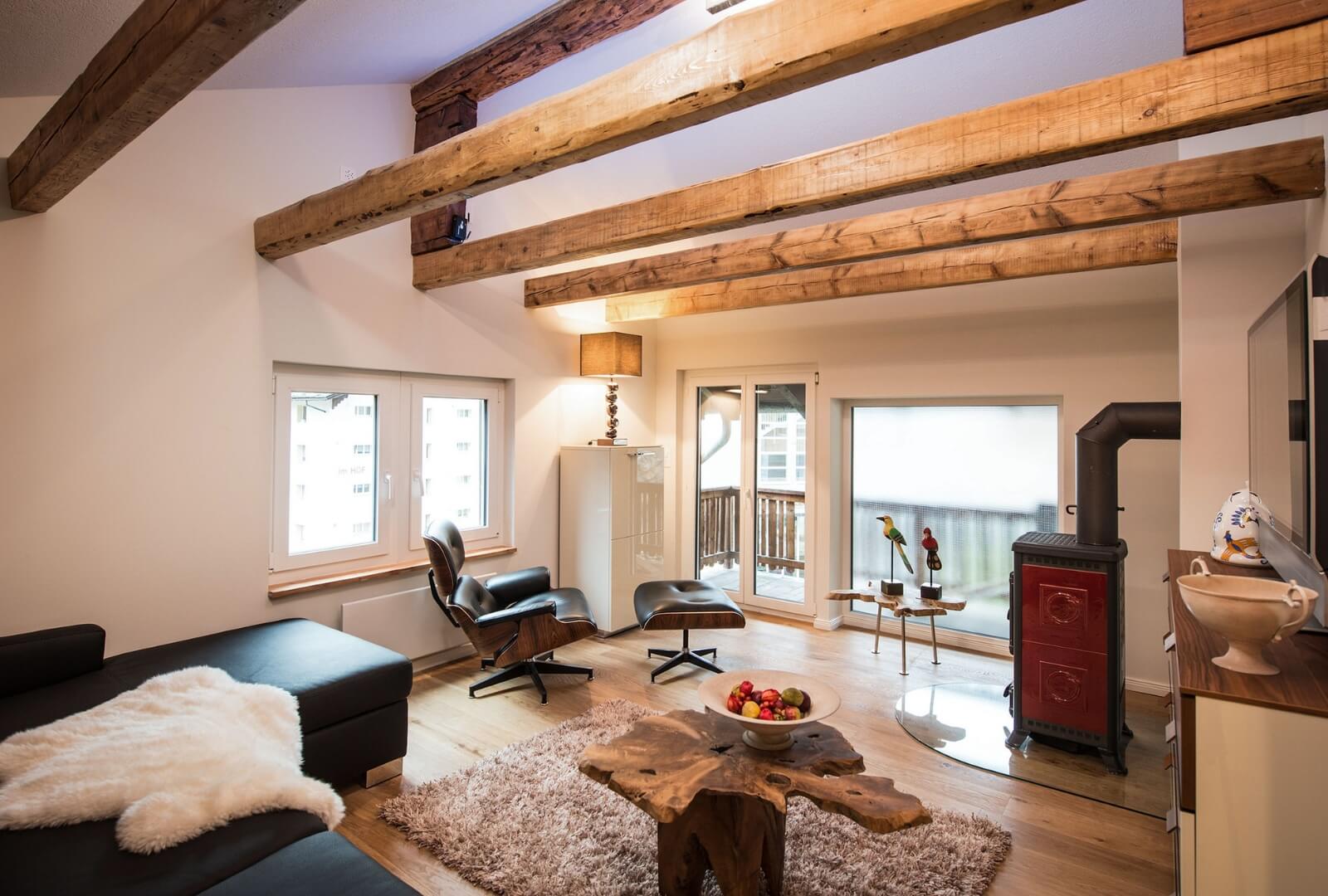 Stylish Chalet Zermatt cozy living room with wooden beams, fireplace, and modern design