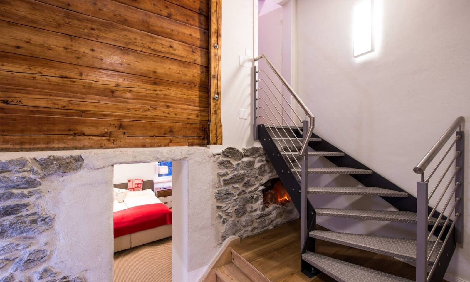 Stylish Chalet Zermatt staircase with stone details leading to bedroom and modern design