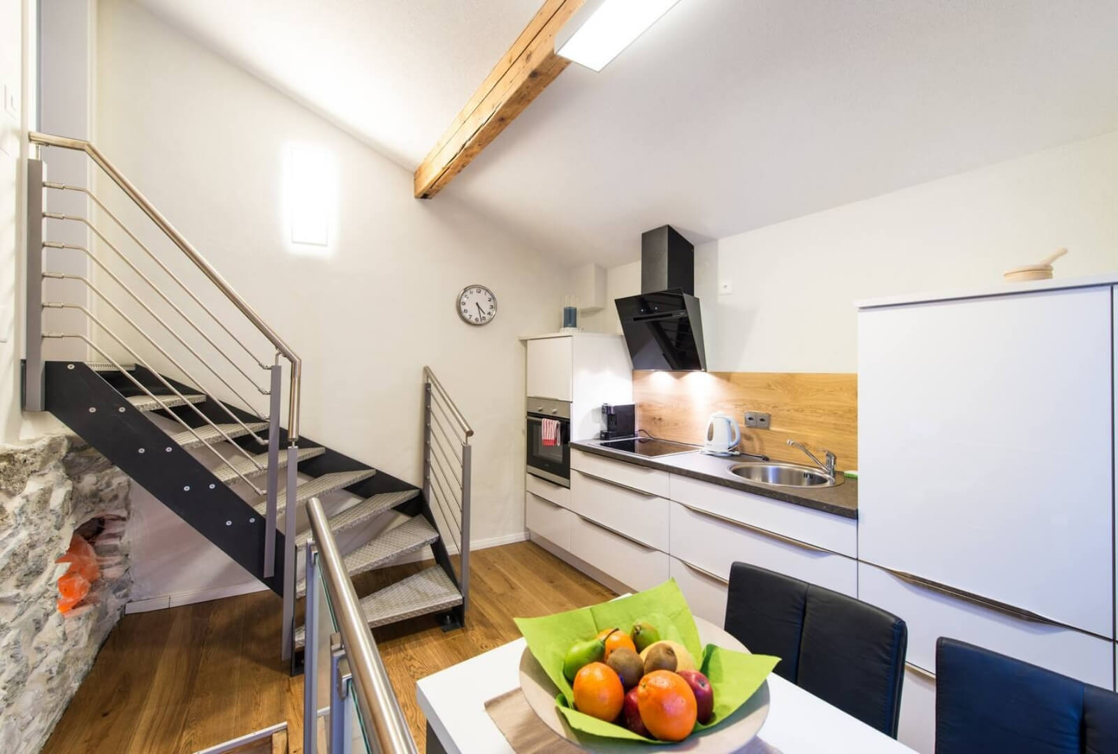Modern kitchen Stylish Chalet Zermatt with dining table, stone accents, and full equipment