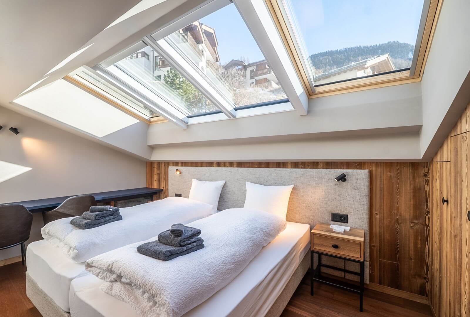 Bright bedroom with skylights at Viscaria Penthouse Zermatt featuring twin beds and alpine wood interior