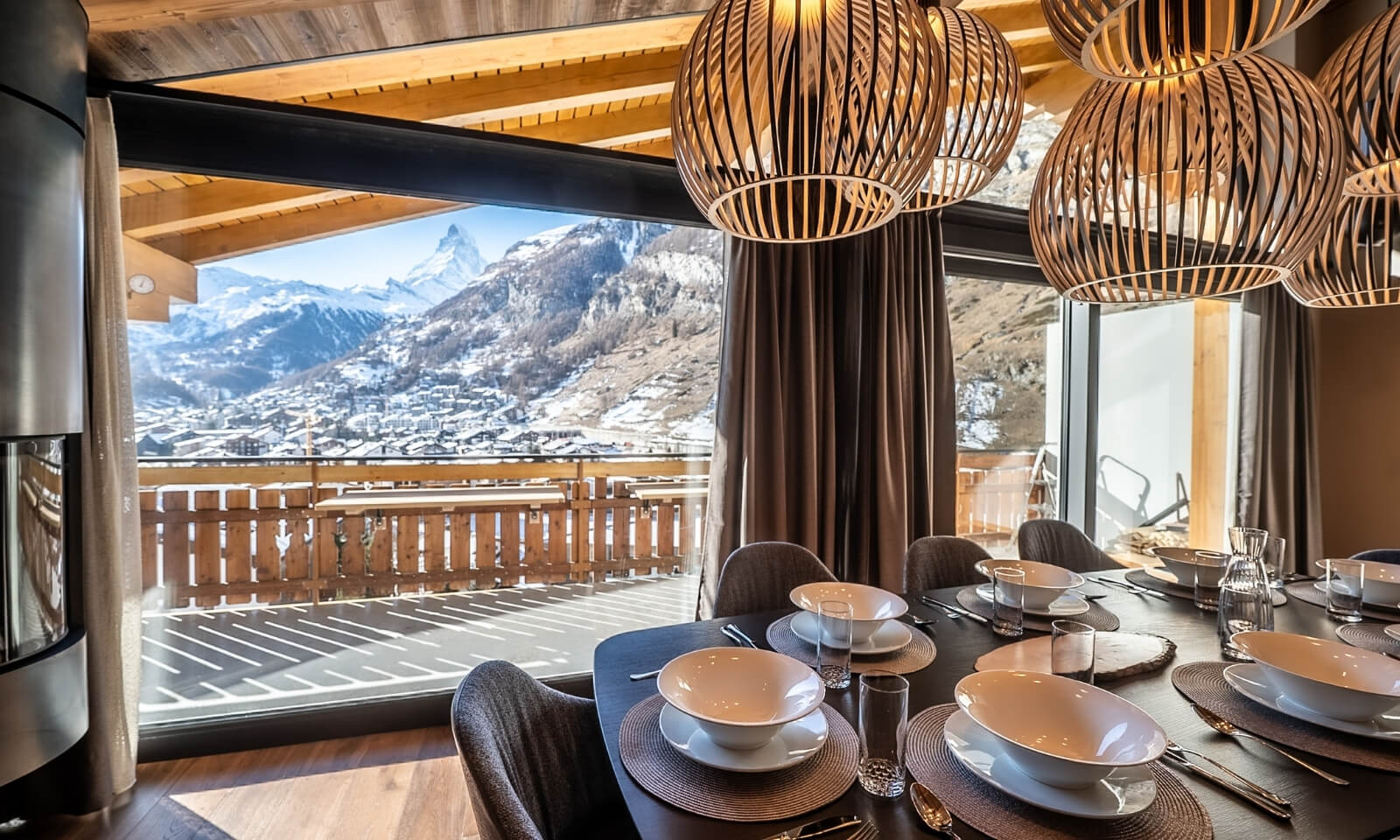 Dining area at Viscaria Penthouse Zermatt with panoramic Matterhorn view through floor to ceiling windows