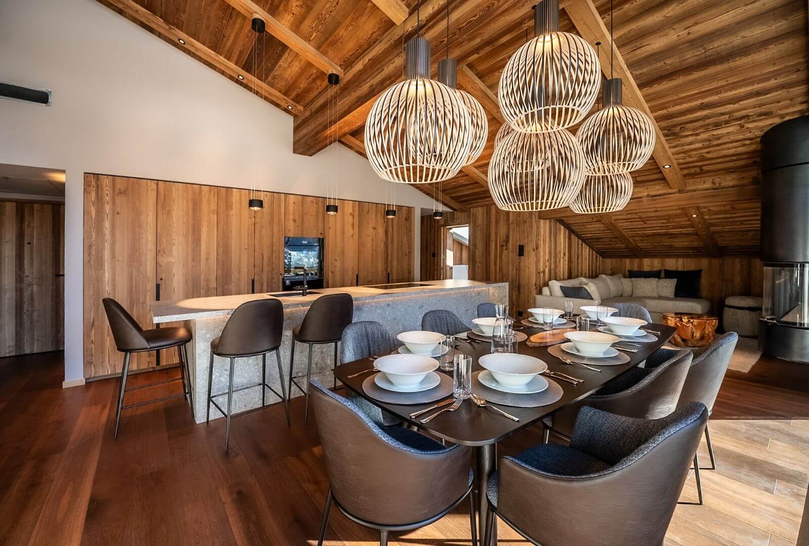 Modern open kitchen and dining area at Viscaria Penthouse Zermatt with wooden ceiling and large dining table