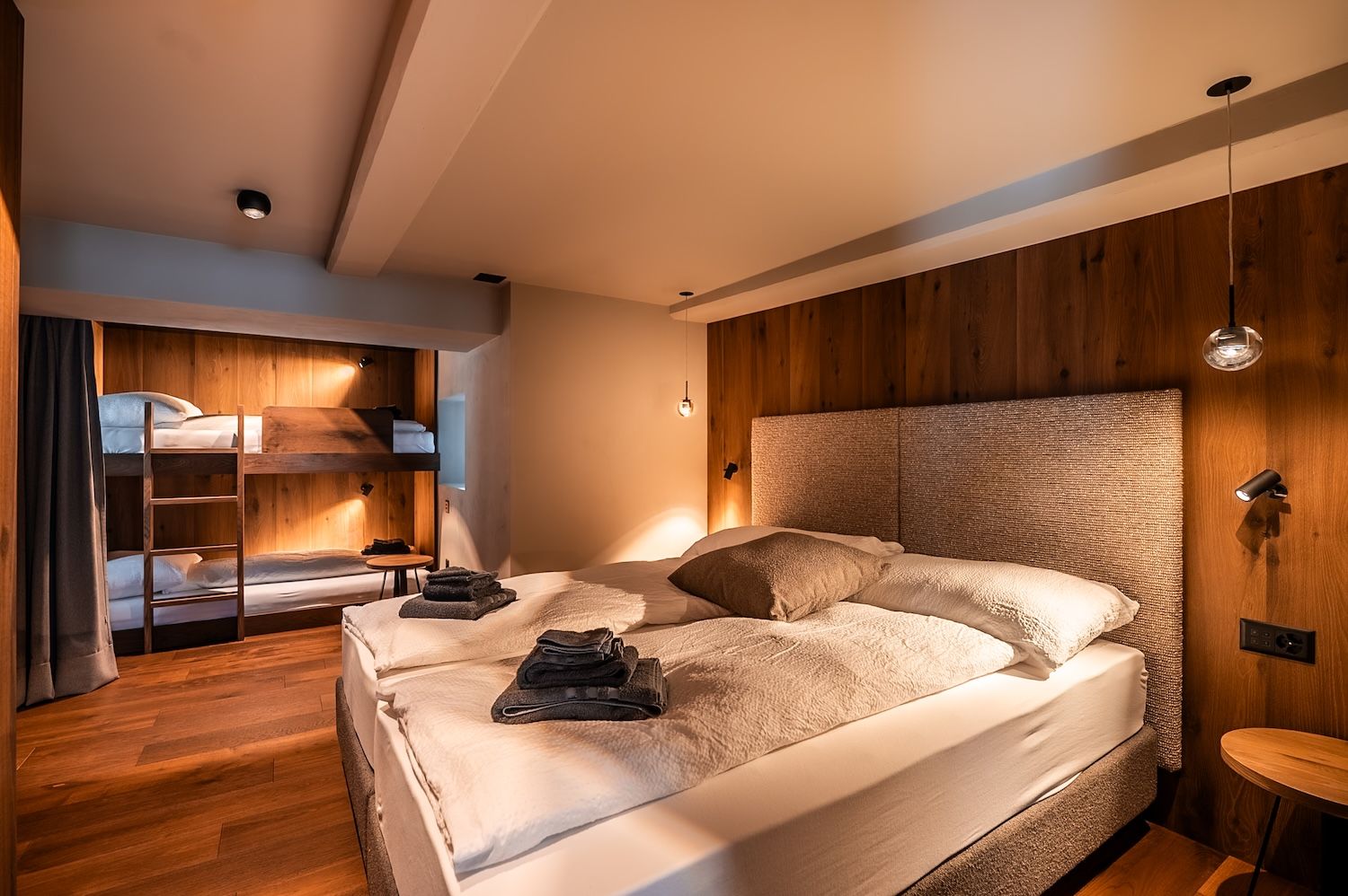 Warmly furnished bedroom with alpine wood details in the "Zermatt Stays" mountain residence