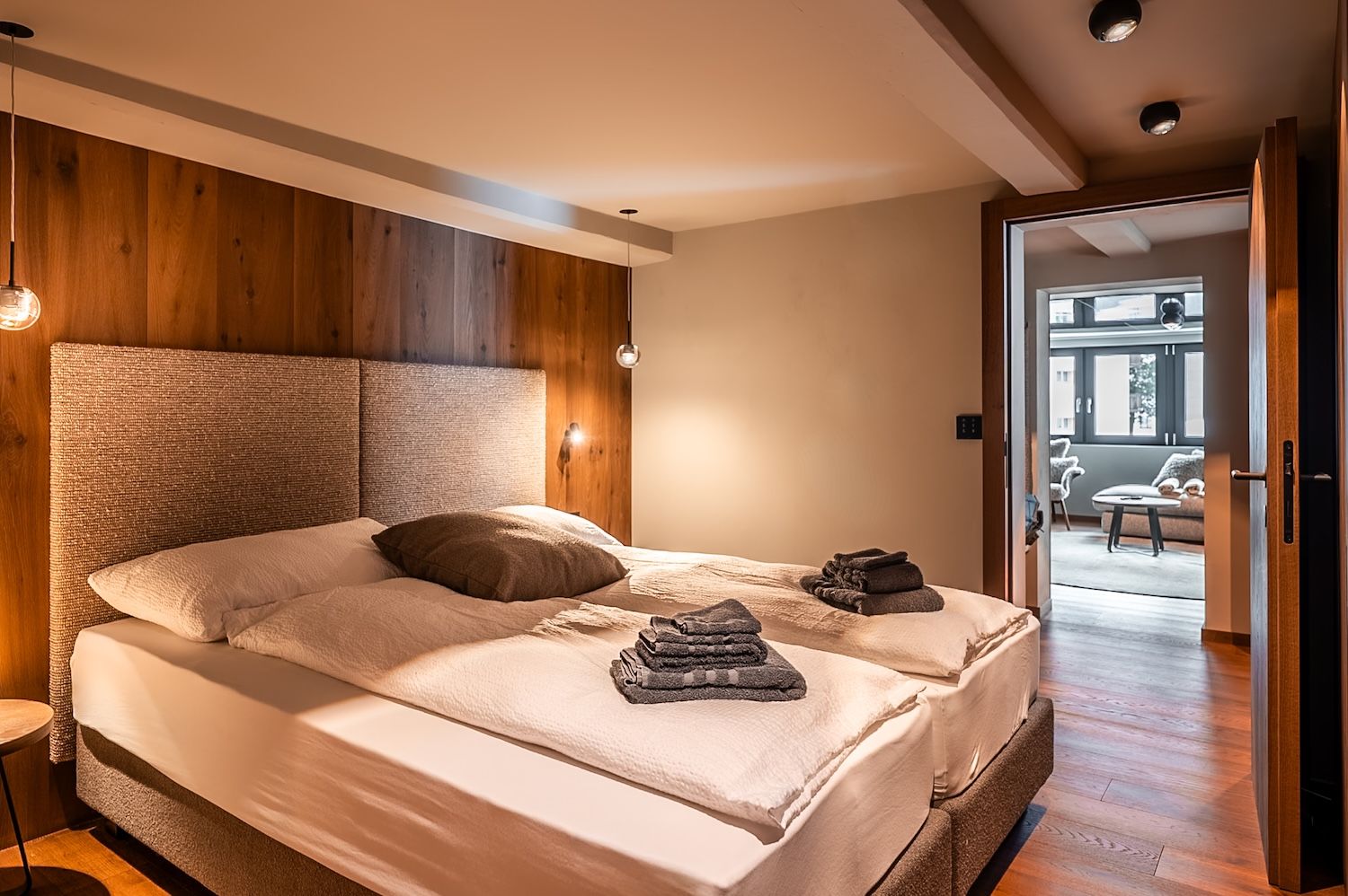 Cozy alpine bedroom with warm wood details in the "Zermatt Stays" mountain retreat