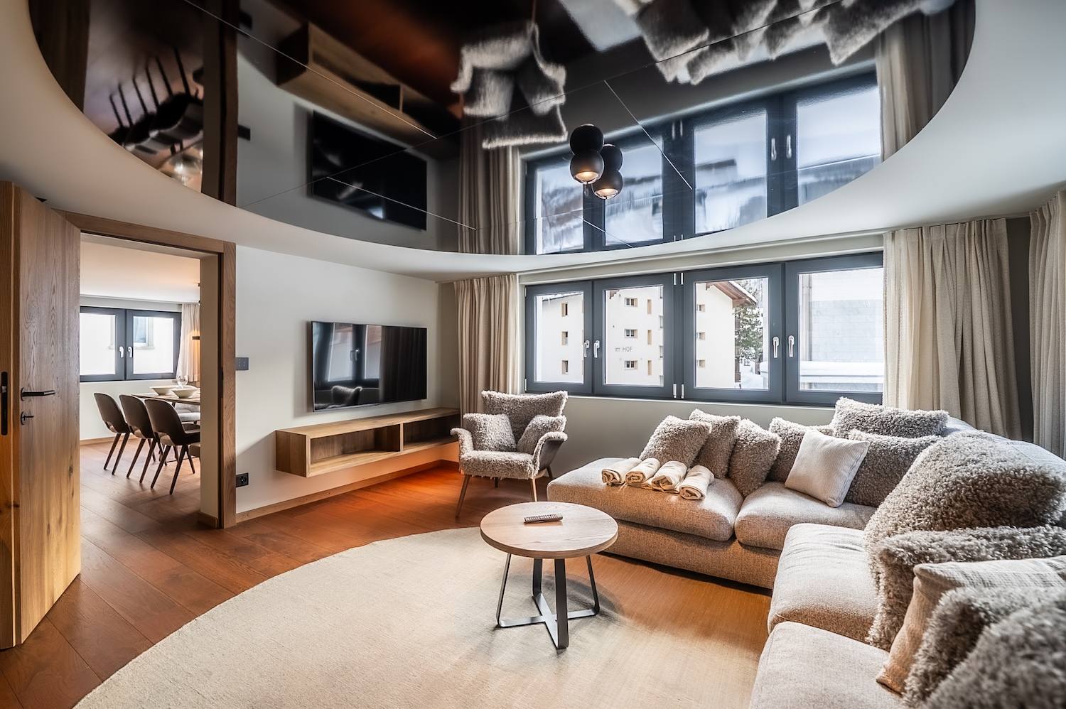 Panoramic living room with expansive windows and mountain-inspired interiors at the "Zermatt Stays" apartment